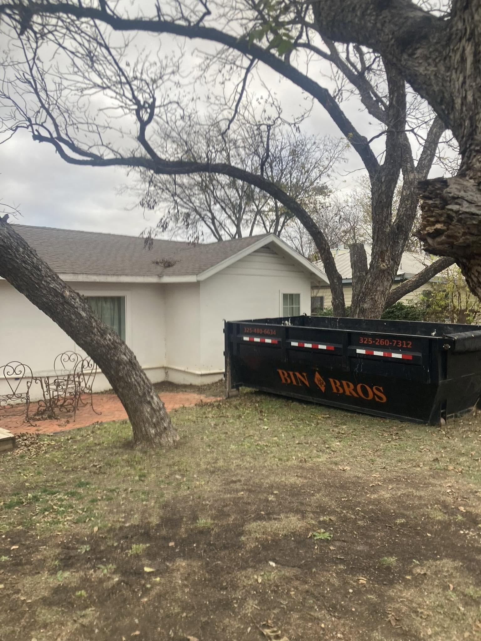 Bin Bros dumpster placed beside a residential property